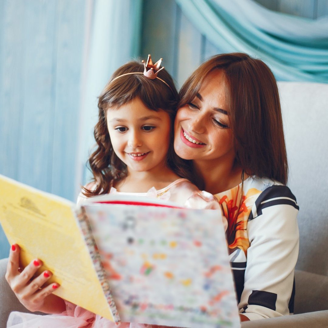 Mom and daughter.The family reads a book. Girls are sitting on a chair